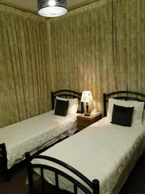 a bedroom with two beds and a table with a lamp at ( b&b ) Gadara rent room in Um Qeis