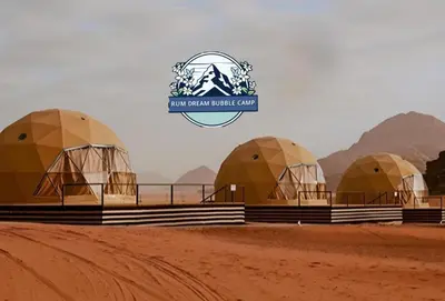 a group of domes in a desert with a logo at RUM DREAM BUBBLES lUXURY CAMP in Wadi Rum