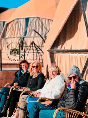 a group of people sitting in chairs on a stage at RUM DREAM BUBBLES lUXURY CAMP in Wadi Rum