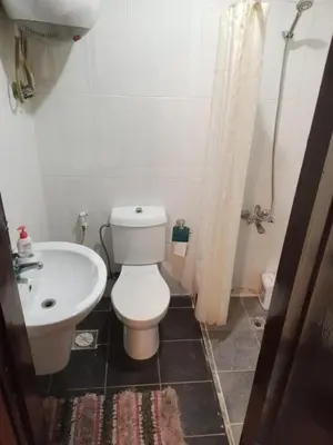 a bathroom with a white toilet and a sink at MK1 - Studio Stay in Amman