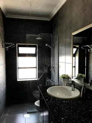 a bathroom with a sink and a toilet and a window at MK6 - Two bedroom Apartment in Amman