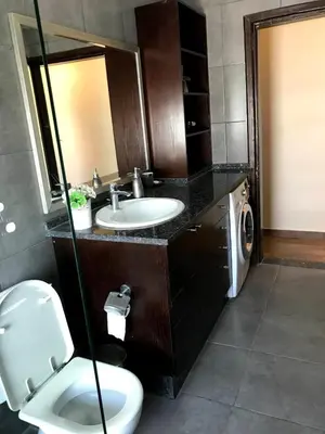 a bathroom with a toilet and a sink and a washing machine at MK6 - Two bedroom Apartment in Amman
