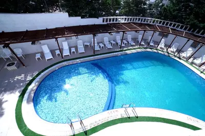 an overhead view of a large swimming pool with chairs at Amman Paradise Hotel in Amman