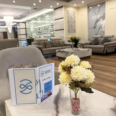 a table with a box and a vase of flowers at Amman Paradise Hotel in Amman