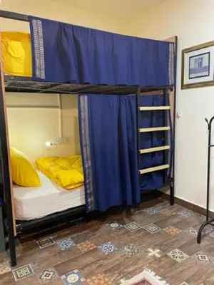 a room with two bunk beds with blue curtains at Darna Hostel in Amman