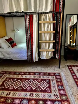 a bedroom with a bunk bed and a rug at Darna Hostel in Amman
