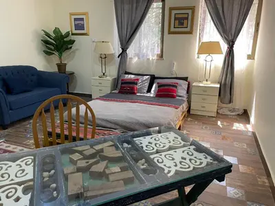 a bedroom with a bed and a blue couch at Darna Hostel in Amman