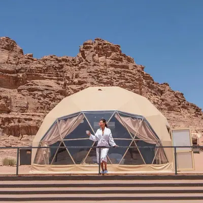 a woman standing in front of a dome tent at Queen's Magic Camp in Wadi Rum