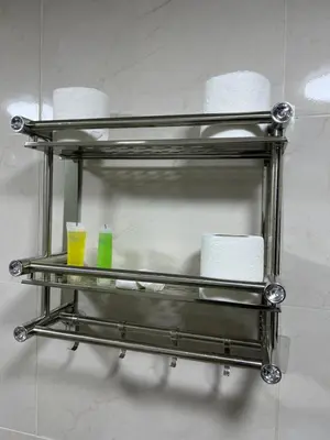 a metal towel rack with toilet paper and two cups at Queen's Magic Camp in Wadi Rum