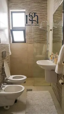 a bathroom with a toilet and a sink at Maison Gaia, A Stylish Apartment in the heart of Amman in Amman