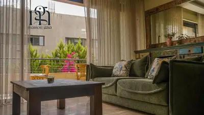 a living room with a couch and a table at Maison Gaia, A Stylish Apartment in the heart of Amman in Amman