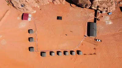 an aerial view of cars parked in the desert at Magic Bedouin Star in Wadi Rum