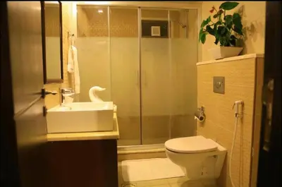 a bathroom with a shower and a toilet and a sink at LANCASTER HOTEL APARTMENTS DAHIET ALRASHEED in Amman