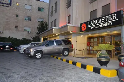 a suv parked in front of a store at LANCASTER HOTEL APARTMENTS DAHIET ALRASHEED in Amman