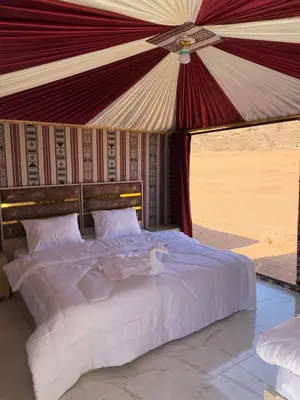 a bedroom with a bed in a tent at Wadi Rum Sand Camp in Disah