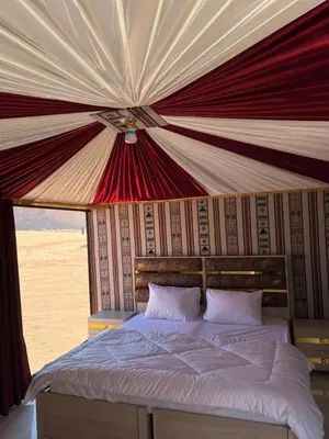 a bedroom with a bed in a tent at Wadi Rum Sand Camp in Disah