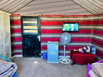 a room with a tent with a fan and a table at Wadi Al-Wala View Camp in Madaba