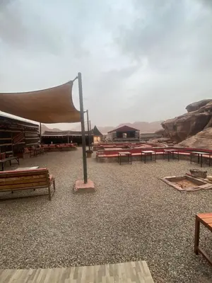 a group of picnic tables and benches in the desert at Enjoy Wadi Rum stars in Disah