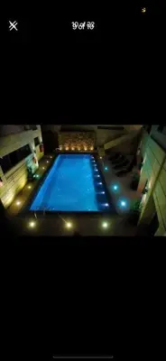 a large blue swimming pool with lights on it at The bridge Residence in Amman