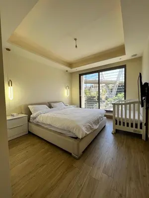 a bedroom with a large bed and a large window at The bridge Residence in Amman