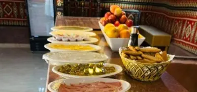 a table with plates of food and bowls of fruit at Awad Bedouin camp in Wadi Rum
