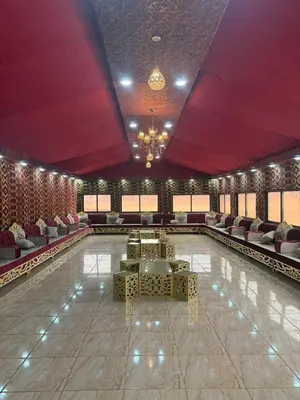 a large room with a pool with couches and chairs at Desert Nights Camp in Wadi Rum