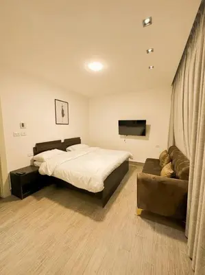 a bedroom with a bed and a couch at central apartment for rent 31 in Umm Uthainah