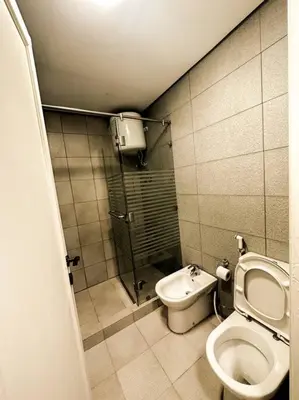 a small bathroom with a toilet and a shower at central apartment for rent 31 in Umm Uthainah