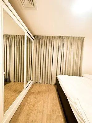 a bedroom with a bed and a large mirror at central apartment for rent 30 in Umm Uthainah
