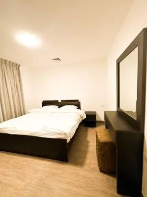 a bedroom with a bed and a mirror and a television at central apartment for rent 30 in Umm Uthainah