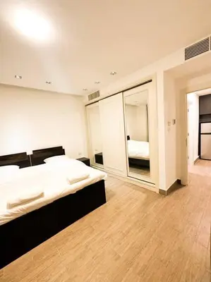a bedroom with a large bed and a mirror at central apartment for rent 29 in Umm Uthainah