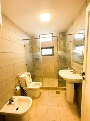 a bathroom with a toilet and a sink at central apartment for rent 29 in Umm Uthainah