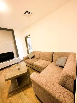 a living room with a couch and a table at central apartment for rent 28 in Umm Uthainah