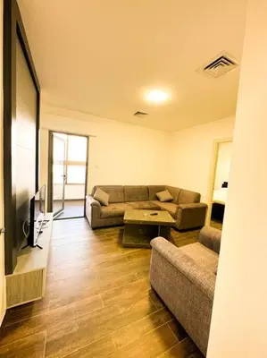 a living room with a couch and a table at central apartment for rent 28 in Umm Uthainah