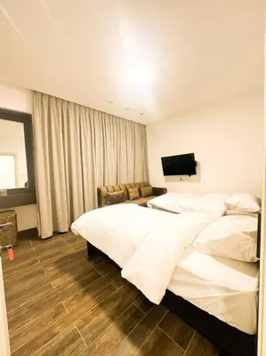 a hotel room with two beds and a flat screen tv at central apartment for rent 24 in Umm Uthainah