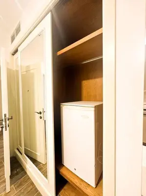 a room with a closet with a refrigerator and a mirror at central apartment for rent 24 in Umm Uthainah