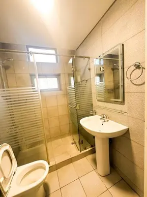 a bathroom with a toilet and a sink and a shower at central apartment for rent 25 in Umm Uthainah
