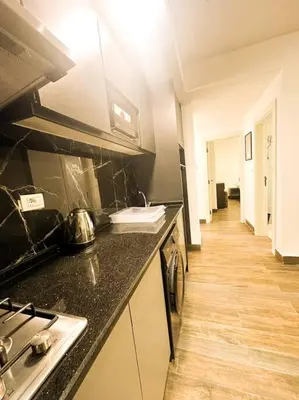 a kitchen with a stove and a counter top at central apartment for rent 25 in Umm Uthainah