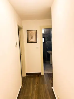 an empty hallway with a hallway leading to a bathroom at central apartment for rent 25 in Umm Uthainah