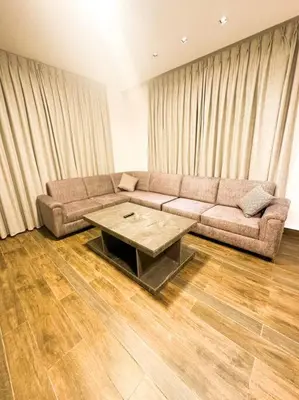 a living room with a couch and a table at central apartment for rent 25 in Umm Uthainah