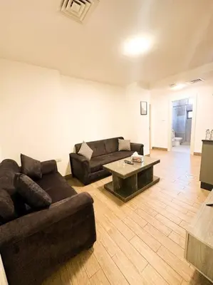 a living room with two couches and a coffee table at central apartment for rent 26 in Umm Uthainah