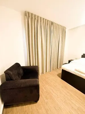 a living room with a chair and a bed at central apartment for rent 26 in Umm Uthainah