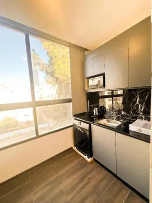 a kitchen with a sink and a stove top oven at central apartment for rent 27 in Umm Uthainah