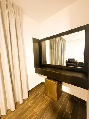 a living room with a mirror and a couch at central apartment for rent 27 in Umm Uthainah