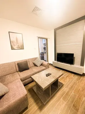 a living room with a couch and a coffee table at central apartment for rent 27 in Umm Uthainah