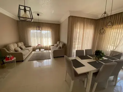a living room with a dining room table and chairs at Modern chic haven in Amman