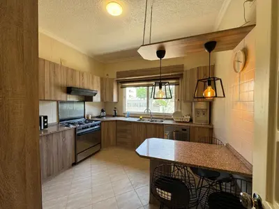 a large kitchen with wooden cabinets and a counter top at Modern chic haven in Amman