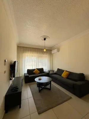 a living room with a couch and a table at Modern chic haven in Amman