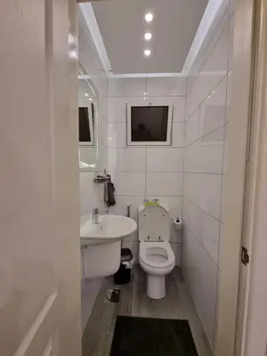 a white bathroom with a sink and a toilet at MK3 - Two Bedroom Apartment in Amman