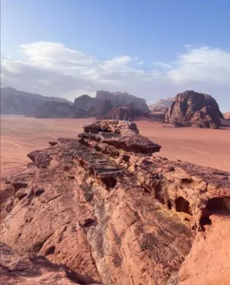a view of the desert with mountains in the background at Golden sunset luxury camp in Wadi Rum